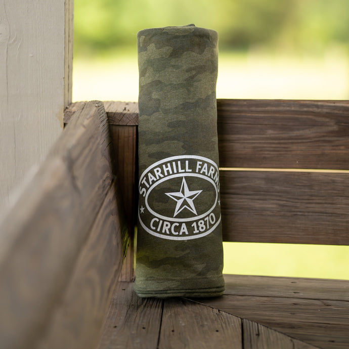 A comfy camo StarHill Farms Blanket pictured at the Ranch House